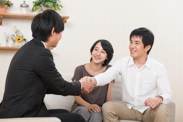 契約の相談を終え、担当者と握手するご夫婦