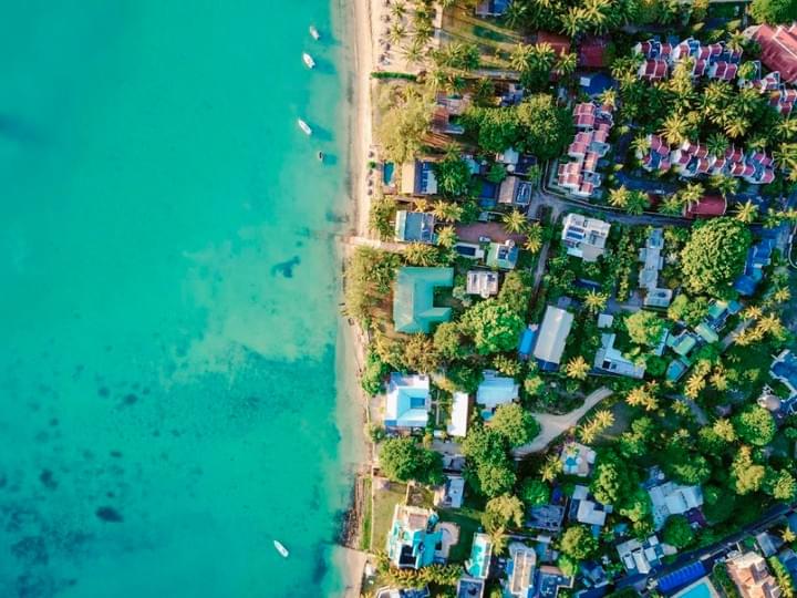 青い海に沿って住まいが並ぶ、海辺の街の風景