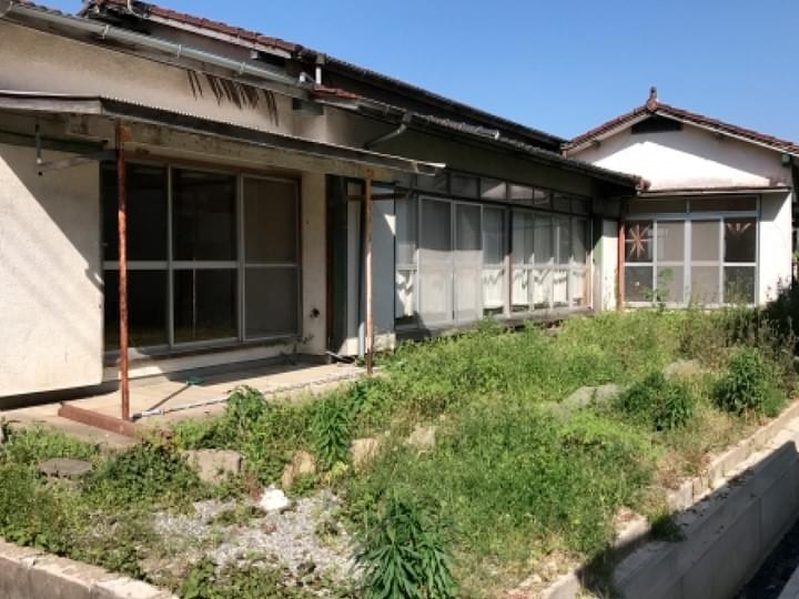庭の草が伸び、日々の手入れが必要な空き家の参考写真